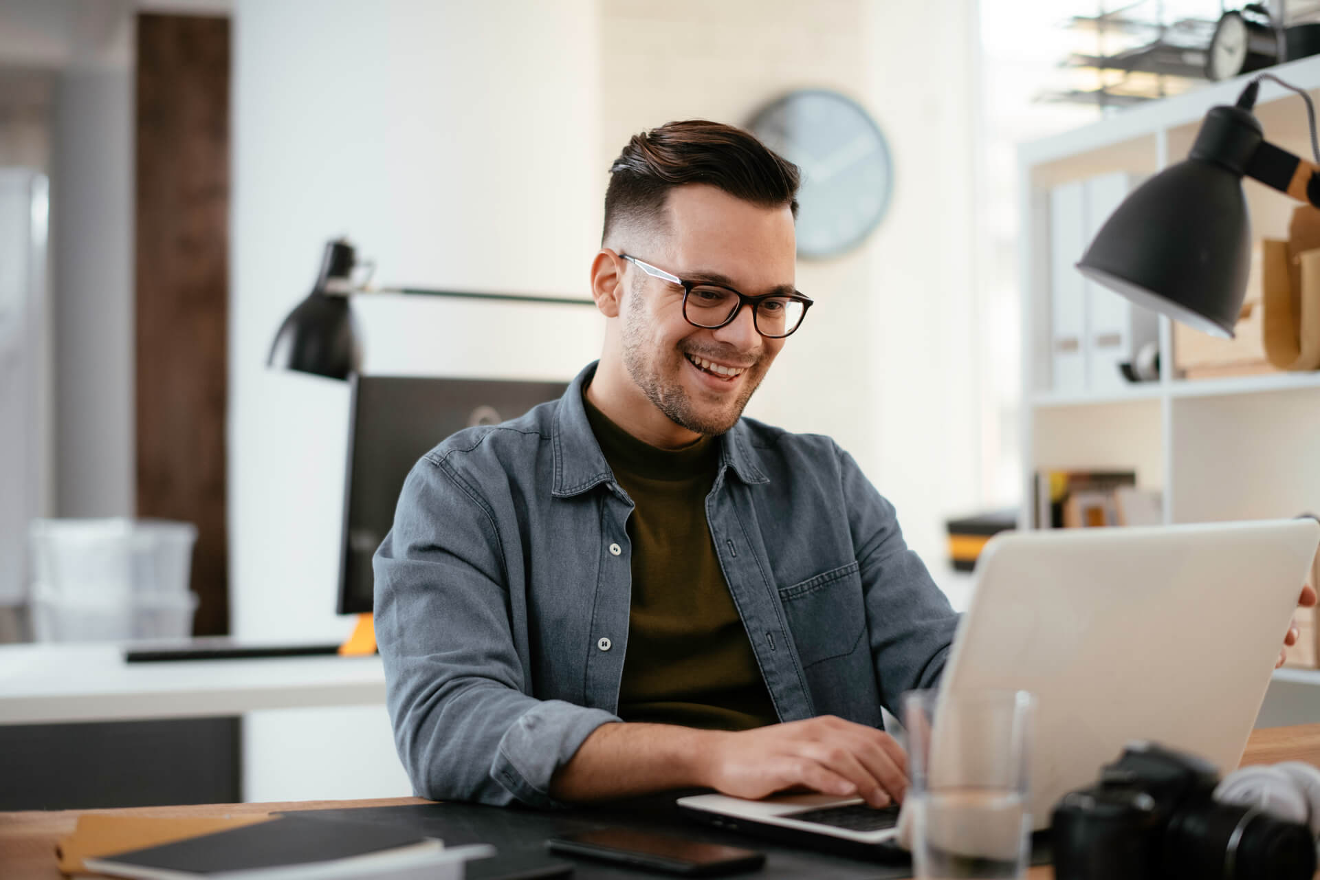 Mann tippt glücklich auf Laptop